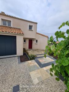a house with a garage in front of it at Chez Caco maison lumineuse avec jardin proche du Puy duFou in Les Herbiers
