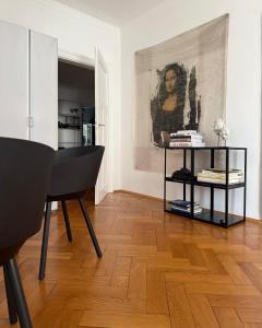 a living room with a table and a painting on the wall at Aussergewöhnlich schönes Zimmer in München-Schwabing in Munich