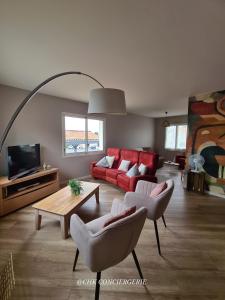 a living room with a red couch and chairs at Chez Caco maison lumineuse avec jardin proche du Puy duFou in Les Herbiers +90 photos