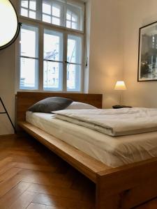 a bed with a wooden frame in a room with a window at Aussergewöhnlich schönes Zimmer in München-Schwabing in Munich