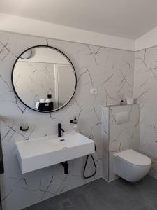 a bathroom with a white sink and a mirror at Apartments Beba55 m in Primošten