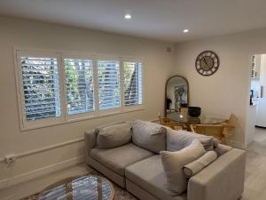 a living room with a couch and a table at Coogee Treehouse in Sydney