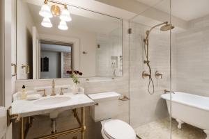a bathroom with a sink and a toilet and a tub at 86 State Circle - Luxury Boutique Hotel in Annapolis