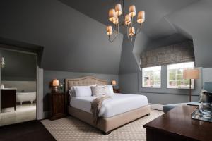 a bedroom with a bed and a chandelier at 86 State Circle - Luxury Boutique Hotel in Annapolis