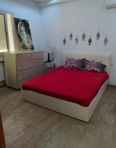 a bedroom with a large bed with a red blanket at Appartement RanYara vue piscine et détentee Hamamet in Nabeul