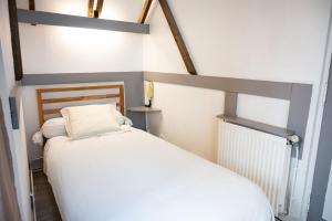 a bedroom with a white bed in a room at Le palais, hôtel - restaurant in Apt