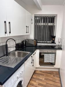 a kitchen with a sink and a dishwasher at 2 Bed Apartment off London Road in Sheffield