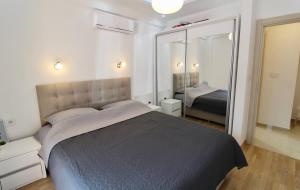 Un dormitorio con una cama grande y un espejo grande. en 1bd Blue Paradise Apt in Tivat Center, en Tivat