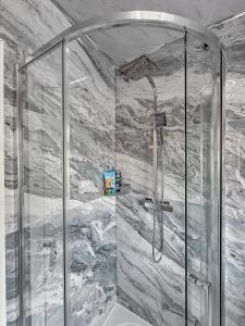 a shower with a glass enclosure in a bathroom at LUTON LUXURY LIVING, Large PREMIUM House, Beautifully Landscaped PRIVATE GARDEN, Newly Refurbished Throughout, PARKING FOR 2 VEHICLES, Great Access to Central Luton & the M1 Motorway in Luton +66 photos