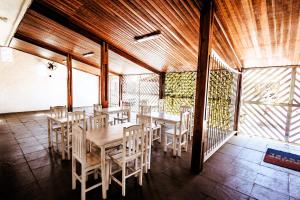 a dining room with wooden tables and chairs at Pousada Peruibe 455 in Peruíbe
