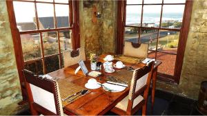 a wooden table with chairs and a laptop on it at Agulhas Country Lodge in Agulhas