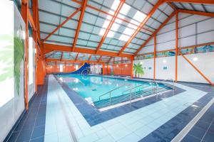 a large indoor swimming pool with a pool slide at Adventure Van 6 berth St Osyth Beach Park in Saint Osyth