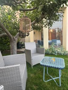 a patio with two chairs and a table and a tree at La Casa Blu Rimini in Rimini