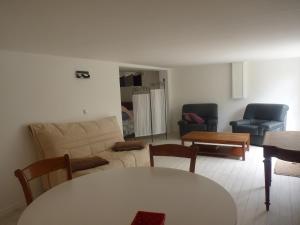 ein Wohnzimmer mit Sofa, Stühlen und einem Tisch in der Unterkunft Logement 30m de la mer! dans maison in Hermanville-sur-Mer + 14 Fotos