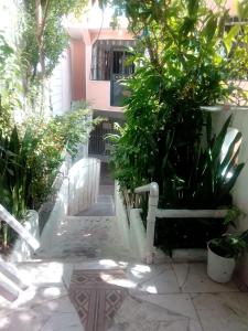 eine weiße Bank, die vor einem Haus sitzt in der Unterkunft Comodo y acogedor apartamento en Los Mameyes in Los Tres Ojos de Agua