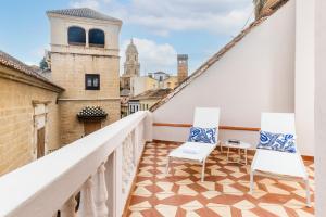 a balcony with two chairs and a view of the city at Picasso III in Málaga