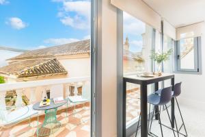 a room with a balcony with a table and chairs at Picasso III in Málaga +14 photos