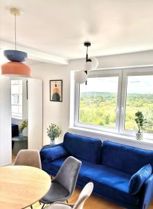 a living room with a blue couch and a table at Dębina Lounge 54 Apartamenty in Debina