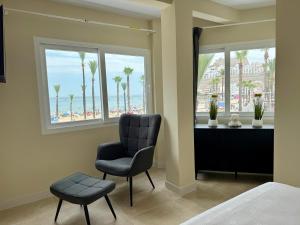a bedroom with a chair and a view of the beach at Besso Somhome in Peñíscola
