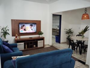 a living room with blue couches and a tv at Casa 55 in Guarapari