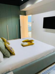 a large bed with yellow pillows and a television at Luxury Mamaia Central in Mamaia