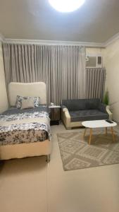 a bedroom with a bed and a couch and a table at أستوديو في الدرعيه in Riyadh