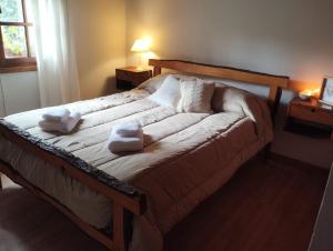 ein Bett in einem Schlafzimmer mit zwei Kissen darauf in der Unterkunft Casas Buen Camino y La Magia in Sierra de la Ventana