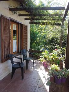 eine Terrasse mit zwei Stühlen und einigen Pflanzen in der Unterkunft Casas Buen Camino y La Magia in Sierra de la Ventana