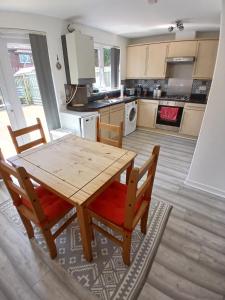 a kitchen with a wooden dining table and chairs at Urban Escape Glasgow Green Free Parking 20min walk to City Center in Glasgow