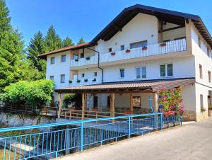 a large white building with a blue fence at Vila Medo in Kulen Vakuf