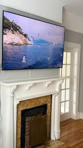 Elle comprend une télévision à écran plat installée au-dessus d'une cheminée. dans l'établissement St Johns spacious Heritage Stay est 1901, à Saint-Jean