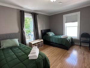 une chambre avec deux lits et une fenêtre dans l'établissement St Johns spacious Heritage Stay est 1901, à Saint-Jean
