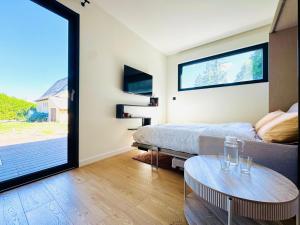 a bedroom with a bed and a table and a window at Domaine du Mafay - LODGE PROVENÇALE in Bourg-des-Comptes