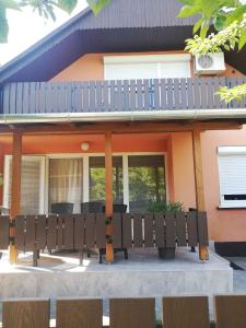 a house with a porch with chairs in front of it at Apartment Balatonfenyves - Balaton 18403 in Balatonfenyves +9 photos