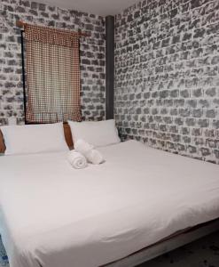 Posto letto in camera con muro di mattoni di Tribal Pai a Pai