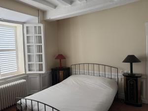 Un dormitorio con una cama con sábanas blancas y una ventana. en Le Manoir de la Seine - proche Giverny, en Bennecourt