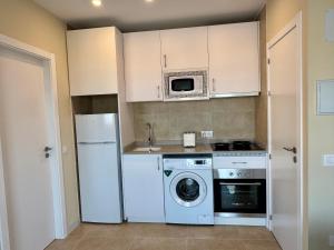 a kitchen with a white refrigerator and a washing machine at Besso Somhome in Peniscola