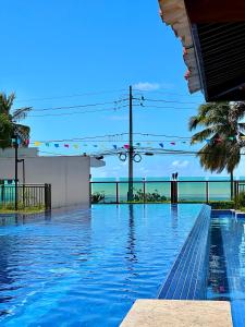 a swimming pool with a view of the ocean at Luxor Paulo Miranda in João Pessoa