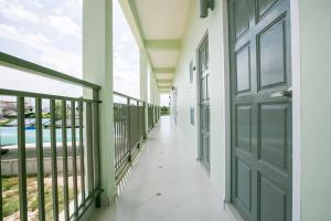 a corridor of a house with a door at J-House Phetchaburi in Phetchaburi