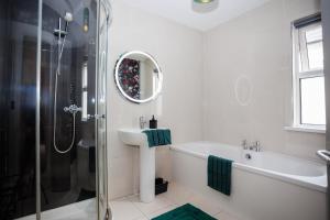 une salle de bain blanche avec lavabo et douche dans l'établissement Raven Willow, à Belfast 33 autres photos
