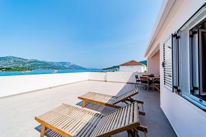 un balcon avec deux bancs et une vue sur l'océan dans l'établissement Apartments by the sea Kneza, Korcula - 168, à Račišće