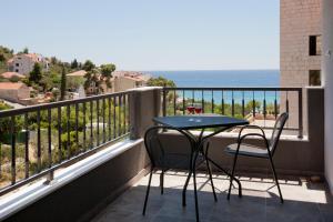 a balcony with a table and chairs and the ocean at Luxurious Apartments Maslina with Beach in Milna