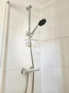a shower with a shower head in a bathroom at Botanica convenient centre Stay free parking in Swindon