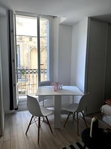 a white table and chairs in a room with a window at T2 Au Coeur de Montpellier in Montpellier +6 photos