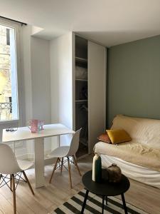 a room with a bed and a table and chairs at T2 Au Coeur de Montpellier in Montpellier