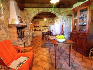 a living room with a table and a stone fireplace at Belvilla by OYO Nonno Raoul in Castel Focognano