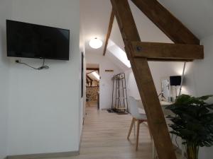 a living room with a flat screen tv on a wall at Gîte pittoresque avec nature, Wi-Fi, BBQ et terrasse privée - FR-1-581-113 in Belhomert-Guéhouville