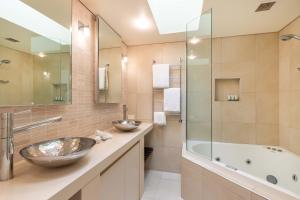 Un baño con dos lavabos y una bañera. en Mirage Resort Villa 106 with access to Sheraton Facilities, en Port Douglas