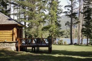 a wooden bench sitting in front of a cabin at Miradas del lago in Epuyén