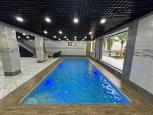 a swimming pool with blue water in a building at Villa Lux I in Chorwoq